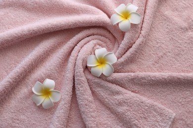 Photo of Pink towel and plumeria flowers as background, top view