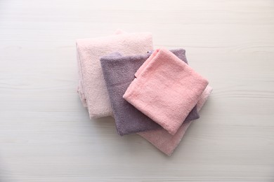Photo of Soft towels on light wooden table, top view