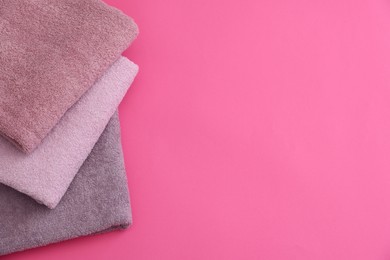 Photo of Soft towels on pink background, top view. Space for text