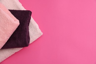 Photo of Soft towels on pink background, top view. Space for text