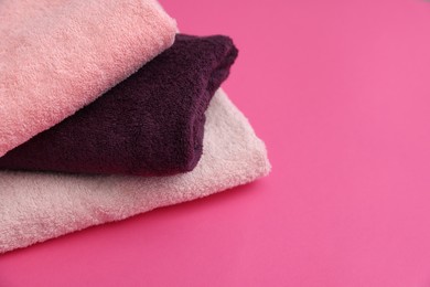 Photo of Soft towels on pink background, closeup. Space for text