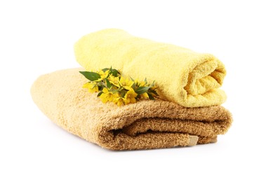 Photo of Soft yellow towels and flowers isolated on white