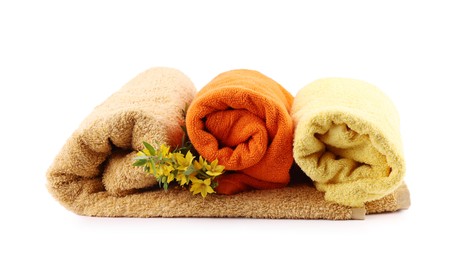 Photo of Rolled towels and flowers isolated on white