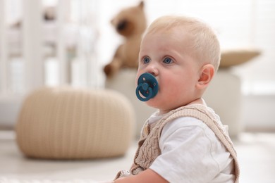 Photo of Cute newborn baby with pacifier in light room. Space for text