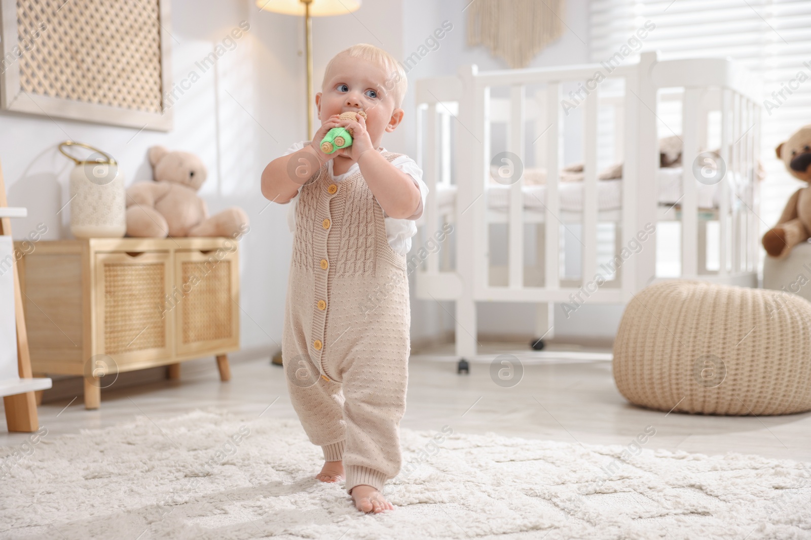 Photo of Cute newborn baby playing with toy in light room