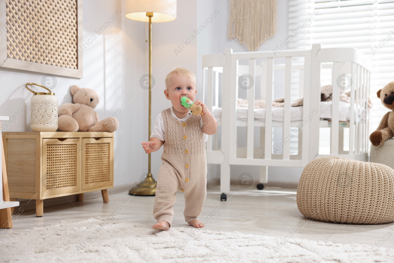 Photo of Cute newborn baby playing with toy in light room