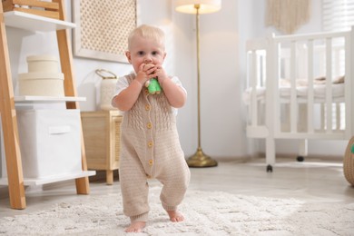 Photo of Cute newborn baby playing with toy in light room