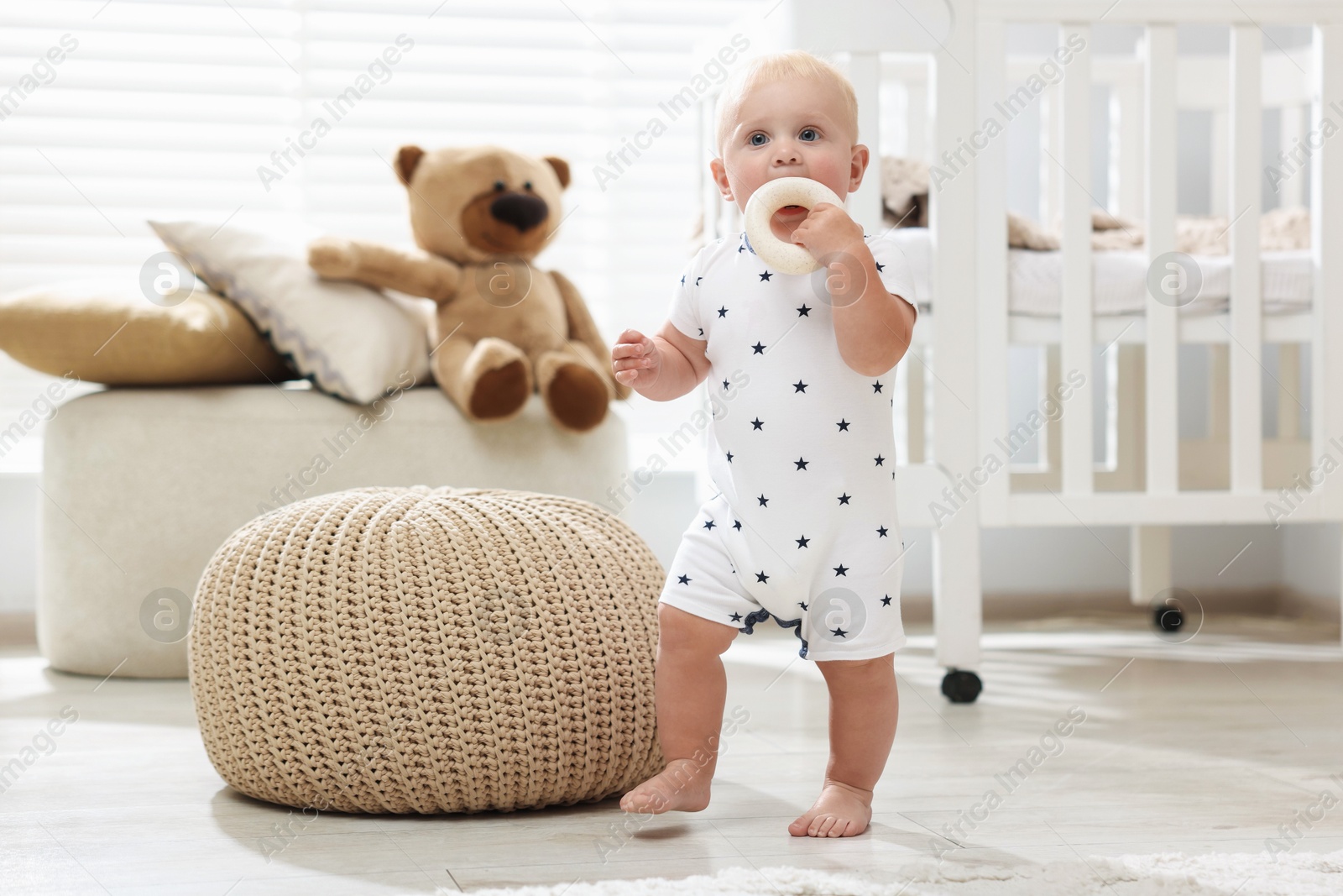 Photo of Cute newborn baby playing with toy in light room