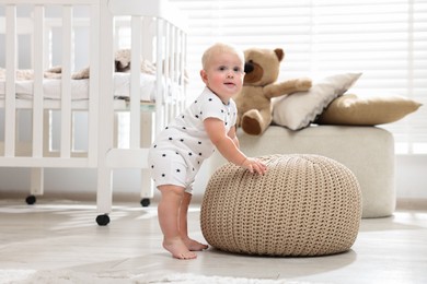 Photo of Cute newborn baby with pouf in light room