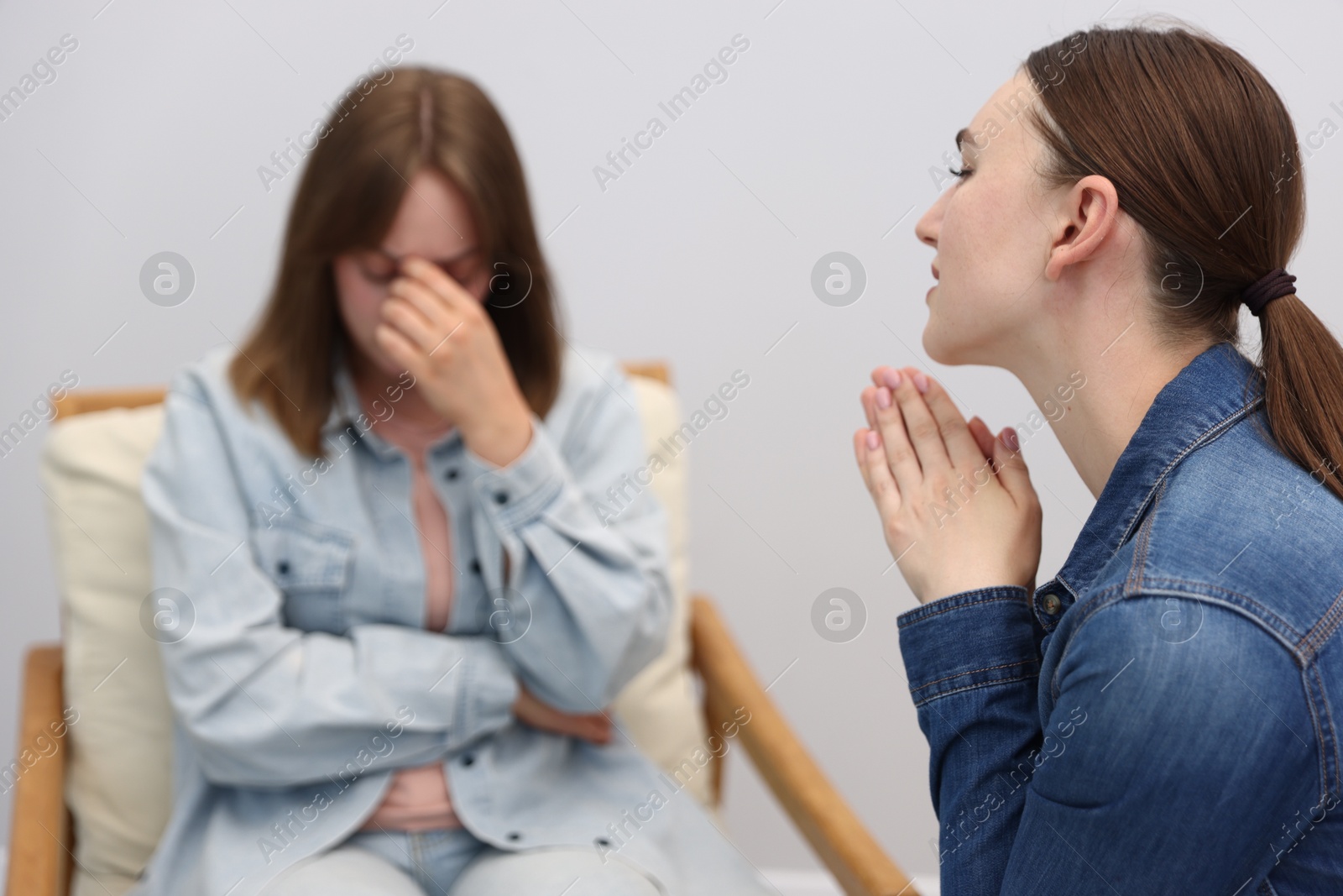 Woman apologizing to her offended friend on armchair at home, selective focus Photo of Woman apologizing to her offended friend on armchair at home, selective focus