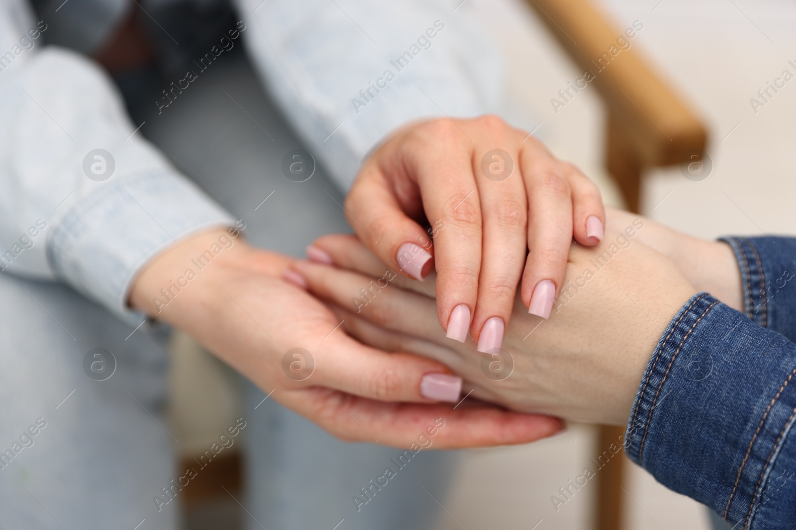 Photo of Friends holding hands after apology indoors, closeup