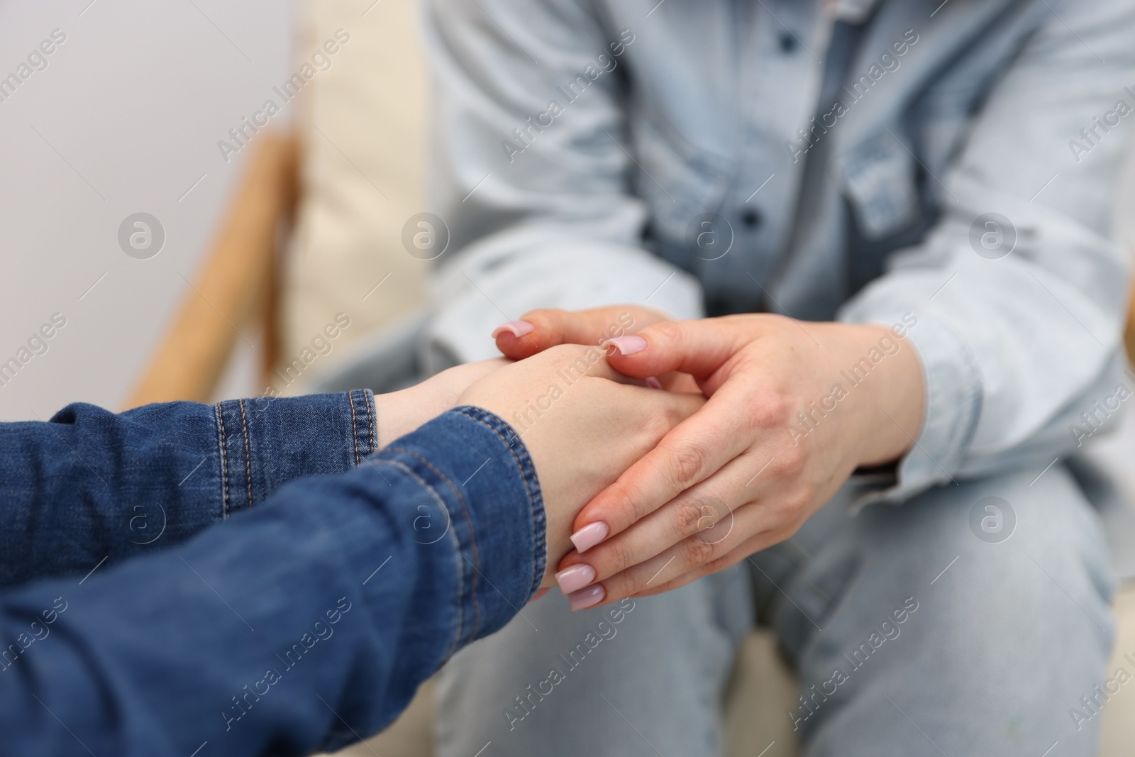 Photo of Friends holding hands after apology indoors, closeup