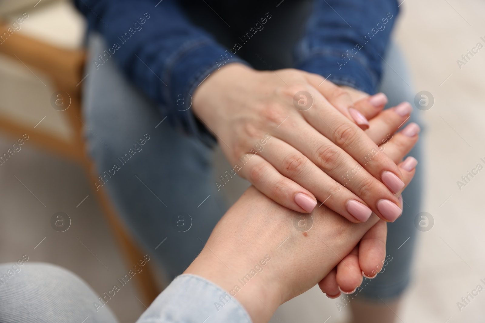 Photo of Friends holding hands after apology indoors, closeup
