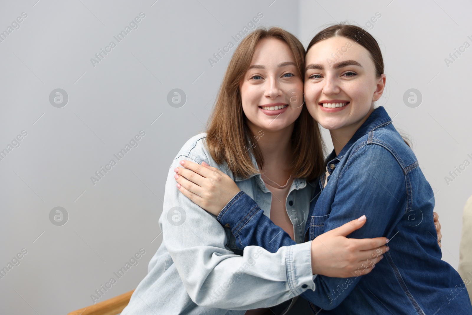 Photo of Happy friends after apology near grey wall at home. Space for text
