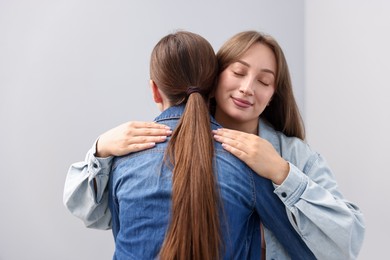 Photo of Friends hugging after apology on grey background