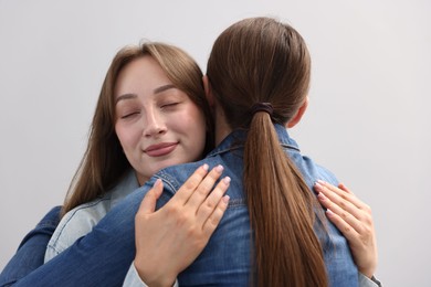 Photo of Friends hugging after apology on grey background