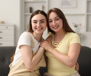 Photo of Happy friends together after apology on sofa at home