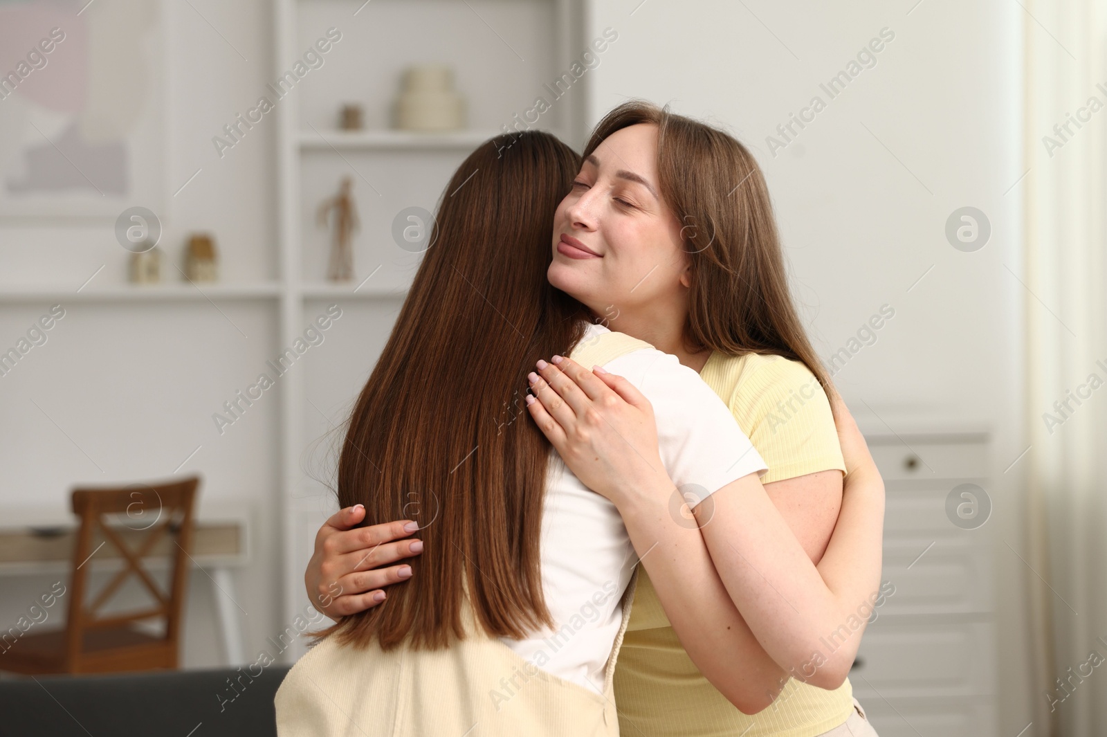 Happy friends hugging after apology at home Photo of Happy friends hugging after apology at home