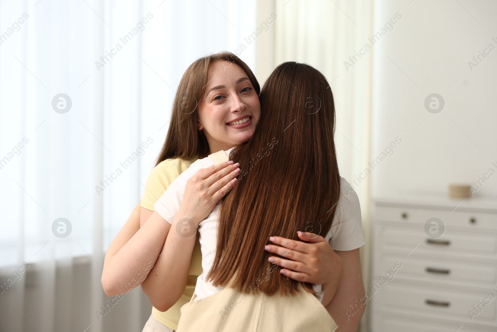 Happy friends hugging after apology at home Photo of Happy friends hugging after apology at home