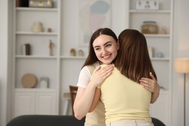 Photo of Happy friends hugging after apology at home. Space for text