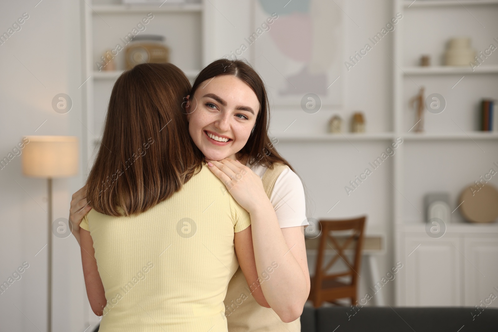 Photo of Happy friends hugging after apology at home. Space for text
