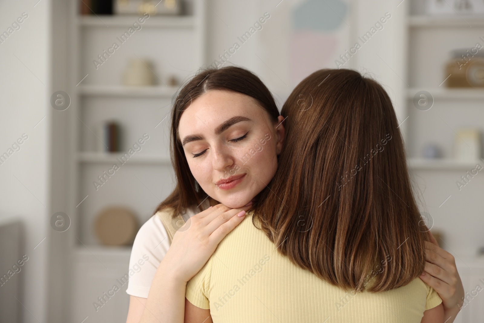 Cute friends hugging after apology at home Photo of Cute friends hugging after apology at home