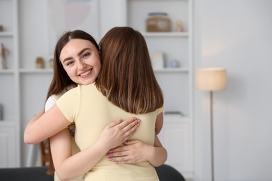 Photo of Happy friends hugging after apology at home. Space for text