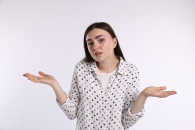 Photo of Portrait of confused woman apologizing on white background