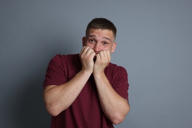 Photo of Man suffering from panic attack on grey background