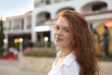 Photo of Portrait of beautiful girl near hotel outdoors, space for text