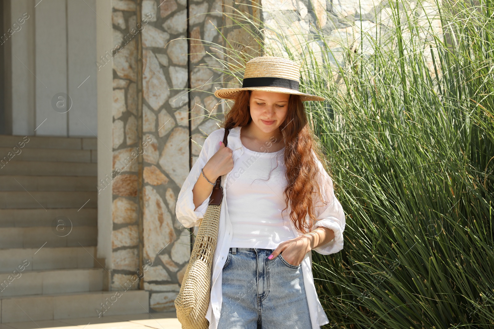 Beautiful girl in straw hat and bag outdoors on sunny day Photo of Beautiful girl in straw hat and bag outdoors on sunny day