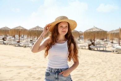 Photo of Beautiful girl in straw hat on sandy beach