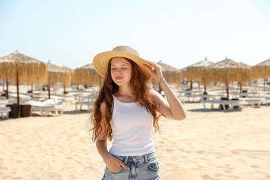 Photo of Beautiful girl in straw hat on sandy beach