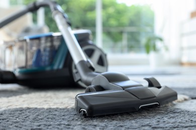 Photo of One vacuum cleaner on floor indoors, closeup. Household appliance
