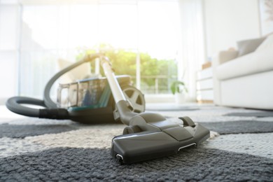 Photo of One vacuum cleaner on floor indoors, closeup. Household appliance