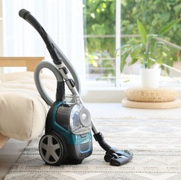Photo of One vacuum cleaner on floor indoors. Household appliance