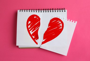 Image of Betrayal. Torn notebook paper with red heart on pink background, top view