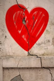 Image of Betrayal. Red heart on cracked old wall