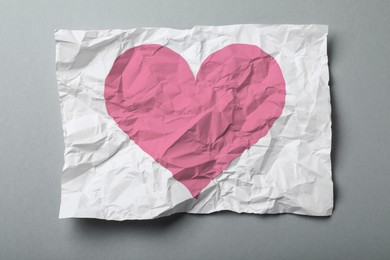 Image of Betrayal. Crumpled sheet of paper with pink heart on grey background, top view