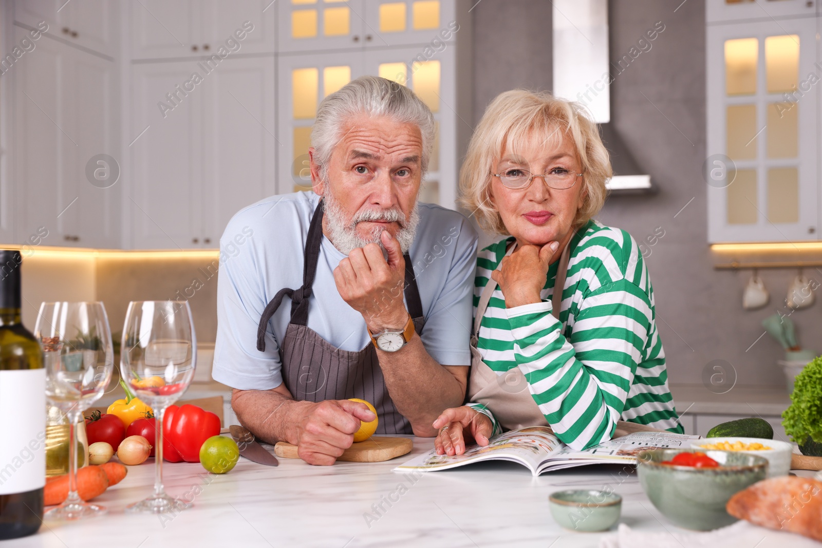 Portrait of elderly couple cooking together at marble table in kitchen Photo of Portrait of elderly couple cooking together at marble table in kitchen