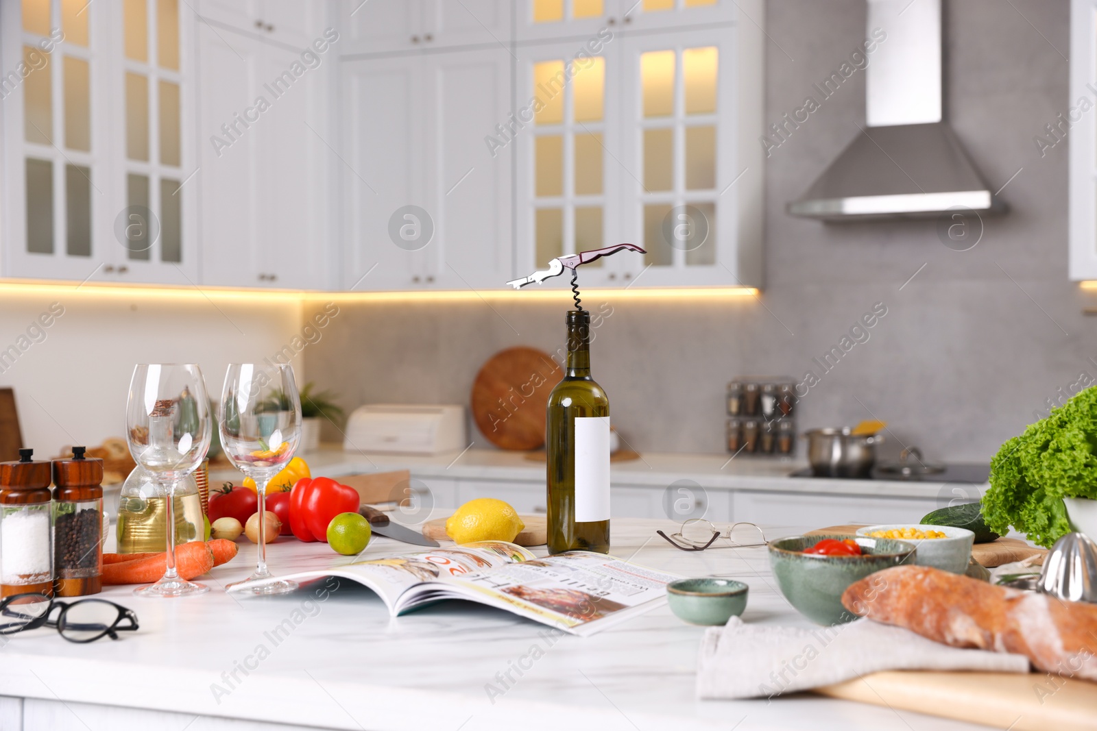 Different products and bottle of wine on counter in stylish kitchen Photo of Different products and bottle of wine on counter in stylish kitchen