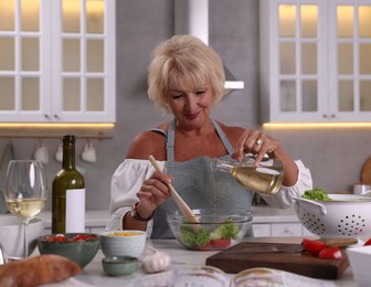 Photo of Senior woman cooking at table in kitchen