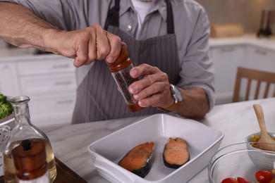 Photo of Elderly man cooking at table indoors, closeup