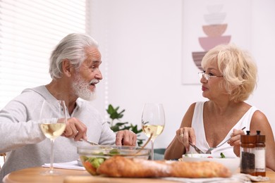Photo of Elderly couple having dinner at table indoors
