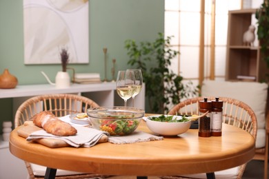Photo of Dinner table with tasty food and white wine in stylish room