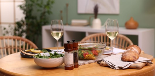 Photo of Dinner table with tasty food and white wine indoors