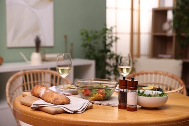 Photo of Dinner table with tasty food and white wine indoors