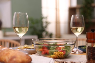 Photo of Tasty food and white wine on table indoors, closeup