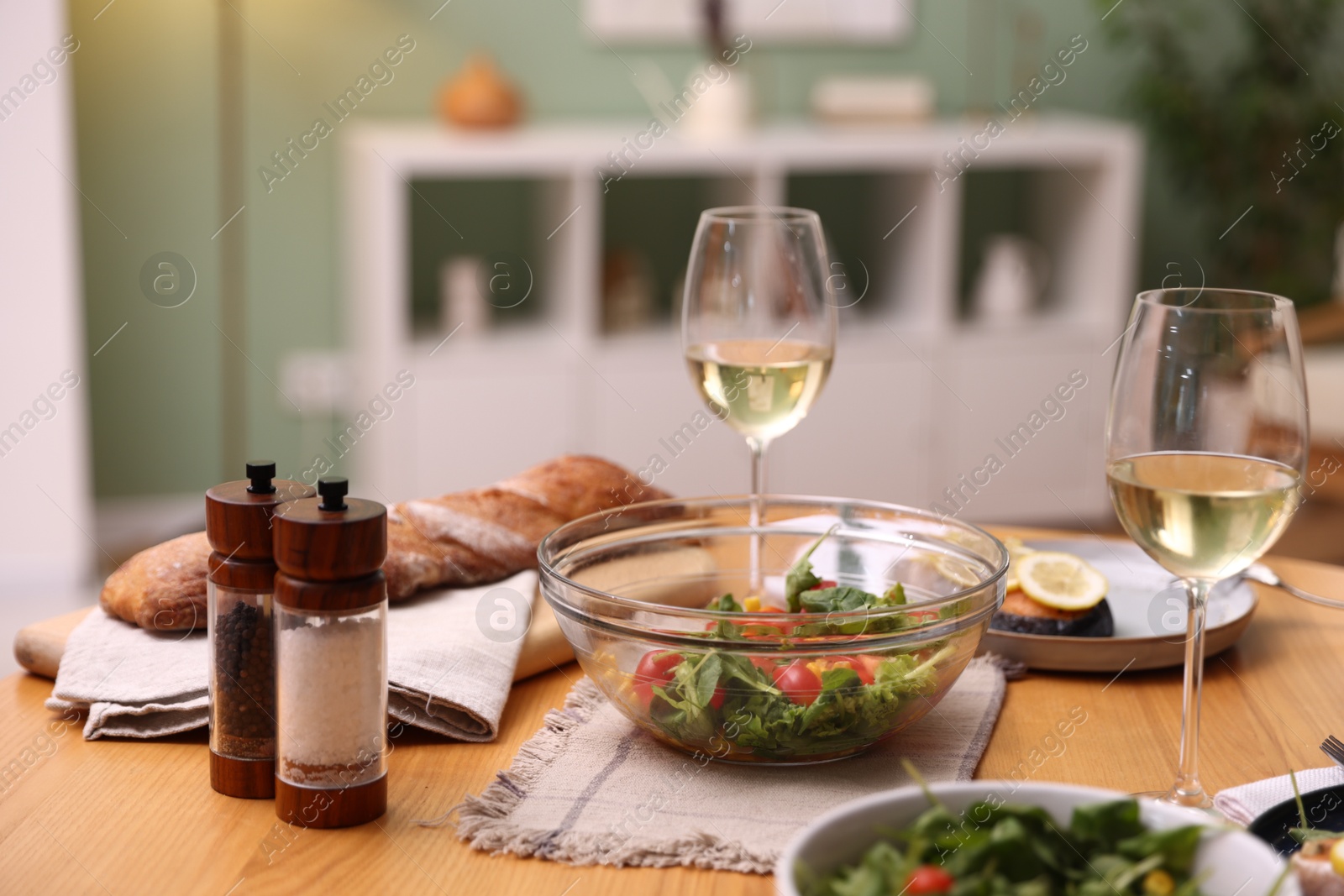 Tasty food and white wine on wooden table indoors, closeup Photo of Tasty food and white wine on wooden table indoors, closeup