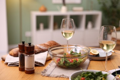 Photo of Tasty food and white wine on wooden table indoors, closeup